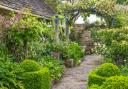 Topiary and plant-covered arches give the garden year-round structure.