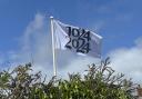 A flag fluttering above Portesham's village green with the millennium logo.