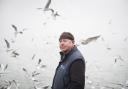 Paul Gilson in Leigh-on-Sea. Seagulls flock around him to collect leftover sprat from a fishing trip