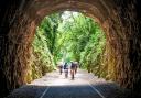 Cycling on the Strawberry Line, part of the National Cycle Network route 26, at Shute Shelve Tunnel near Axbridge in Somerset.