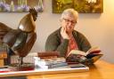 Writer, May Ellis sits at her locally bought dining table, one of the tables that lead her writings in a new direction.