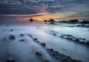 Waves break into rock pools at Welcombe Beach