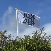 A flag fluttering above Portesham's village green with the millennium logo.