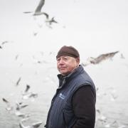 Paul Gilson in Leigh-on-Sea. Seagulls flock around him to collect leftover sprat from a fishing trip