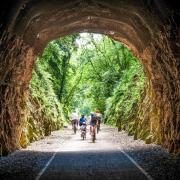 Cycling on the Strawberry Line, part of the National Cycle Network route 26, at Shute Shelve Tunnel near Axbridge in Somerset.