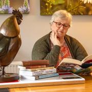 Writer, May Ellis sits at her locally bought dining table, one of the tables that lead her writings in a new direction.