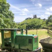 Reconstruction of the narrow-guage railway with train and waggons that used to transport the ball clay, with Corfe Castle in the background. (Photo: Purbeck Mining Museum)