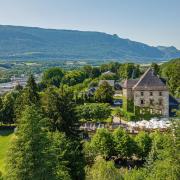 The Château de Candie is a 14th century castle with ivy-covered walls with a lush forest backdrop.