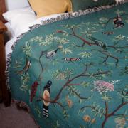 The Arcana 'Forest Flight' blanket features 21 species of Belizian birds.